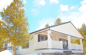 Une maison moderne à deux étages, dotée d’un porche abrité, d’un numéro bien visible « 813 » et d’un sol enneigé.