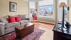 A living room with a sofa, a wooden chest, a rug, a lamp, and a ceiling fan. - Historic 2BR Home, Downtown Leadville, Mountain Vi (Leadville)