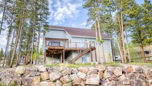 A two-story house with a wooden deck and a staircase leading to a second floor. - 3BR - Hot Tub, Jacuzzi, Stunning Mt. Elbert Views (Leadville)