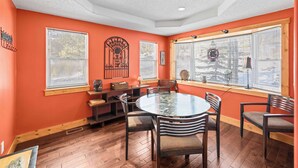 A dining area with a round table, chairs, and a window with blinds. - 3BR - Hot Tub, Jacuzzi, Stunning Mt. Elbert Views (Leadville)