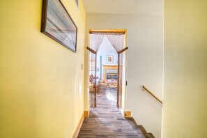 A hallway with a wooden staircase leading to a room with a bed and a desk. - 3BR - Hot Tub, Jacuzzi, Stunning Mt. Elbert Views (Leadville)