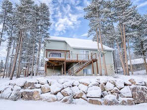 A two-story house with a wooden deck and a staircase leading to a balcony. - 3BR - Hot Tub, Jacuzzi, Stunning Mt. Elbert Views (Leadville)