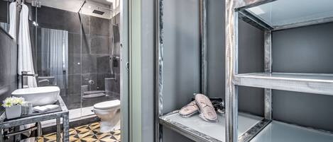 A modern bathroom with a glass shower enclosure, a toilet, and a sink.