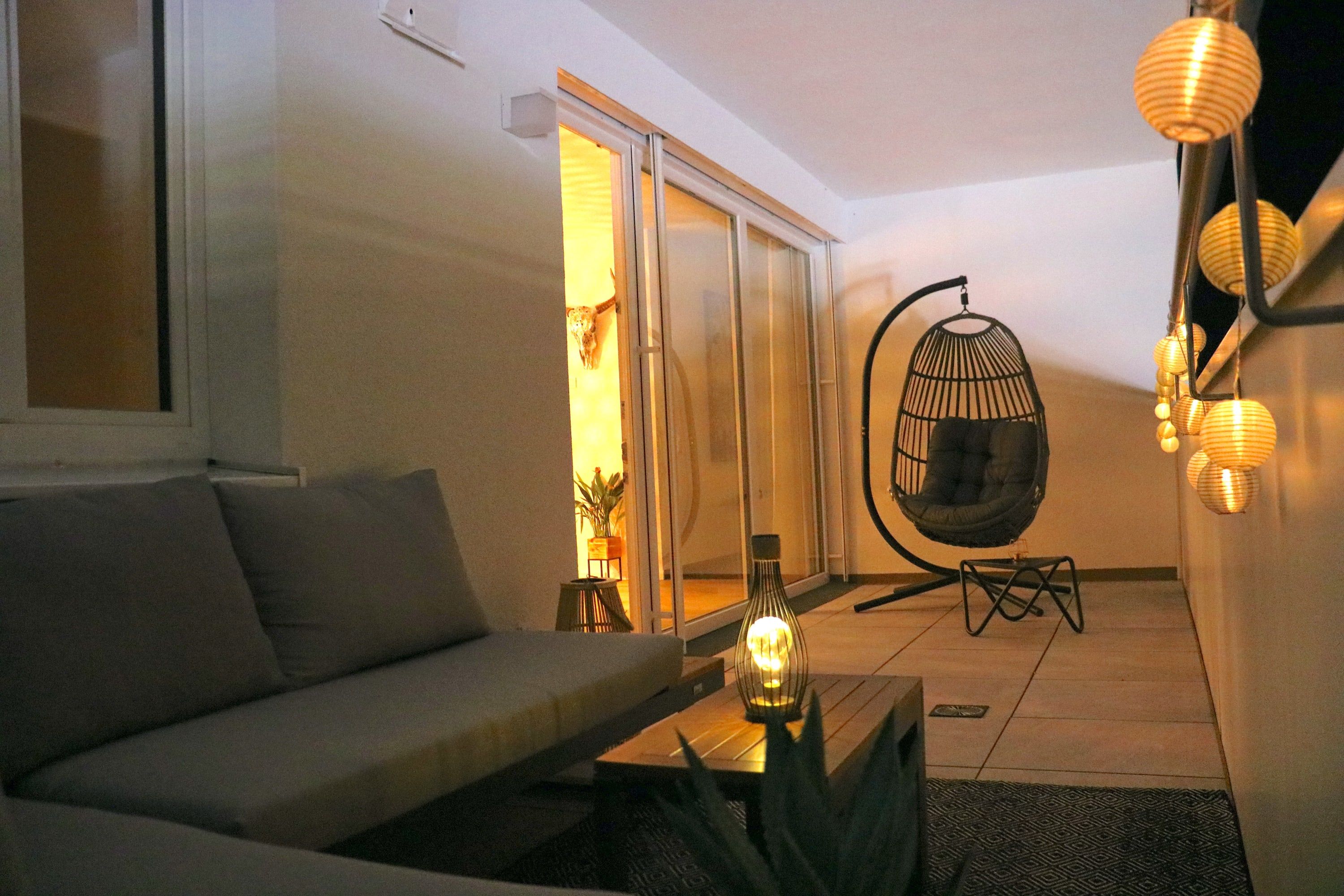 A modern living room with a sofa, a hanging chair, and a coffee table.
