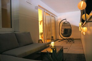 A modern living room with a sofa, a hanging chair, and a coffee table. - Lakeview Penthouse: Terrace, Free Parking, (Gmunden)