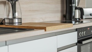 Una cocina moderna con cafetera, hervidor y tostadora sobre la encimera.