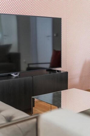 Een moderne entertainmentkast met een flatscreen televisie, donker houten afwerking en een glazen plank.