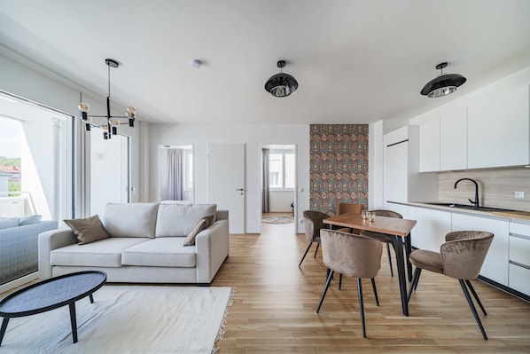 Una sala de estar moderna con sofá, mesa de centro y comedor con sillas.