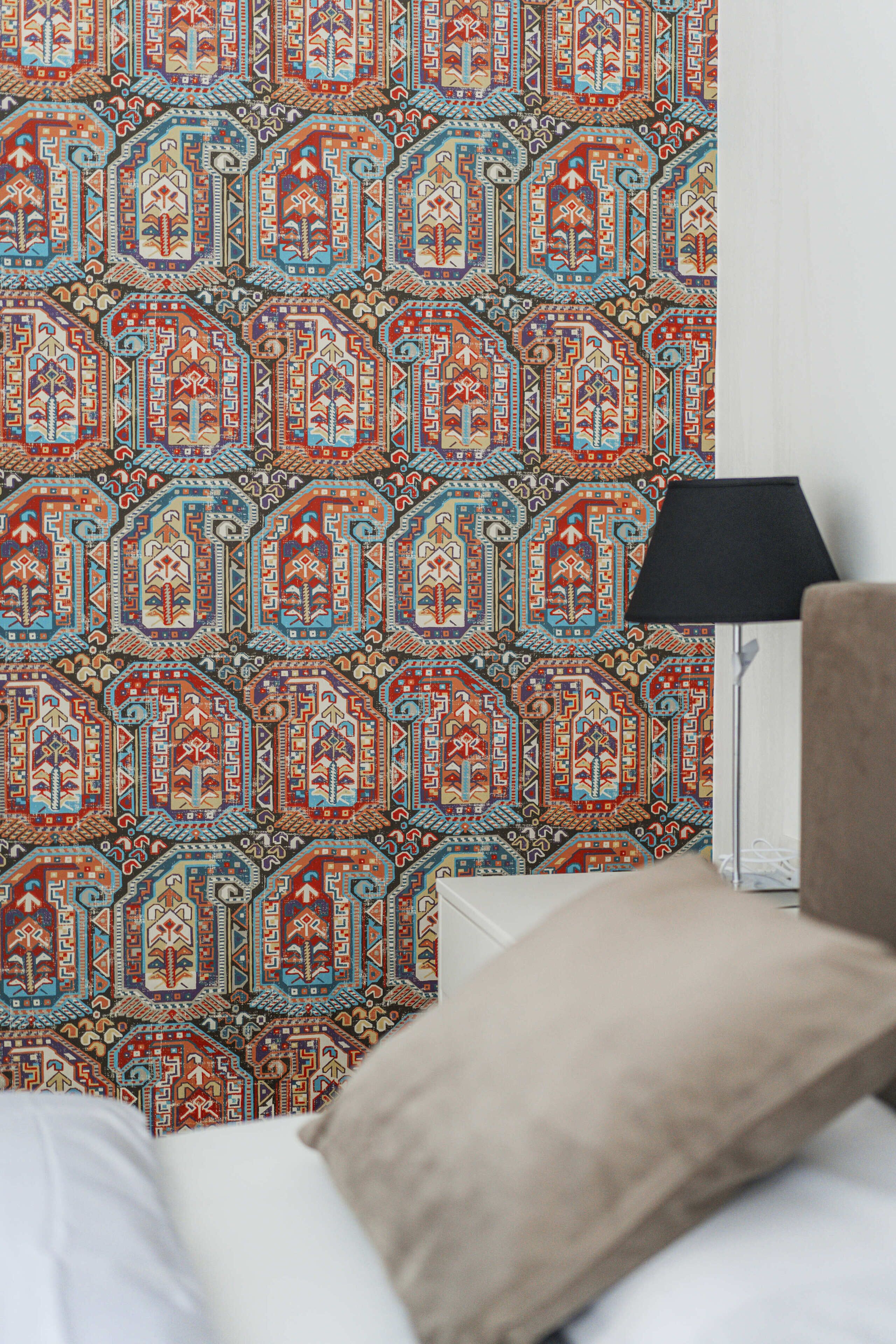 A room with a patterned wallpaper, a bedside lamp, and a bed with a pillow.