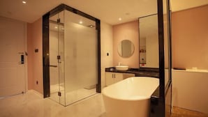 A modern bathroom with a glass-enclosed shower, a freestanding bathtub, and a vanity with a mirror. - Changxing Hainabaichuan Hotel (Changxing)
