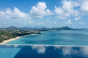 Vista costera con cielo despejado, playa y una extensa masa de agua.