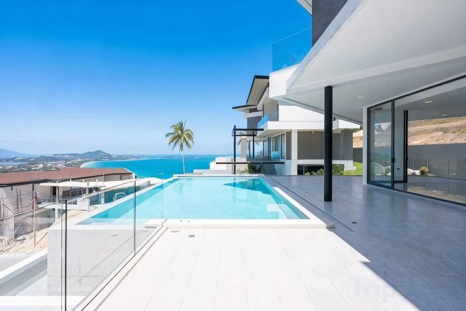 Una casa moderna con piscina, balcón y vista al mar.