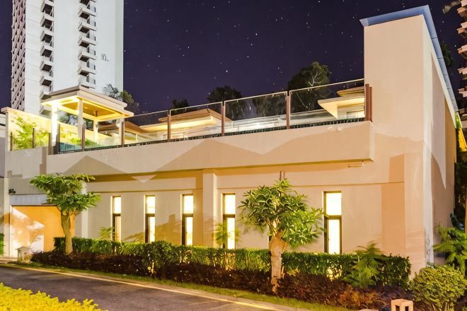 Un edificio moderno con balcón, ventanas amplias y una entrada bien iluminada.