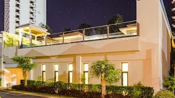 Un edificio moderno con balcón, ventanas amplias y una entrada bien iluminada.