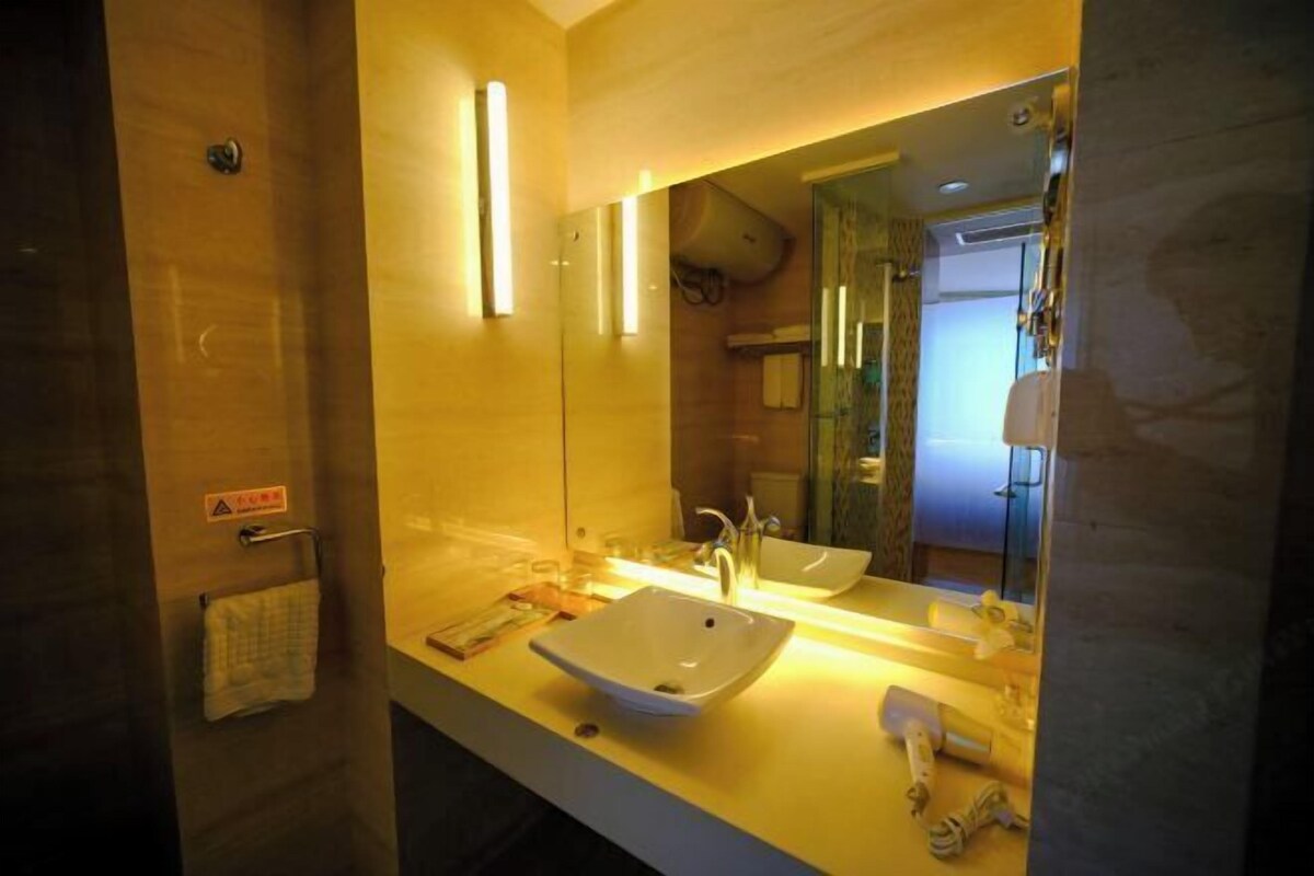A bathroom with a white sink, mirror, and towel rack.