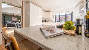 Una cocina moderna con armarios blancos, encimera de granito y vistas al exterior.