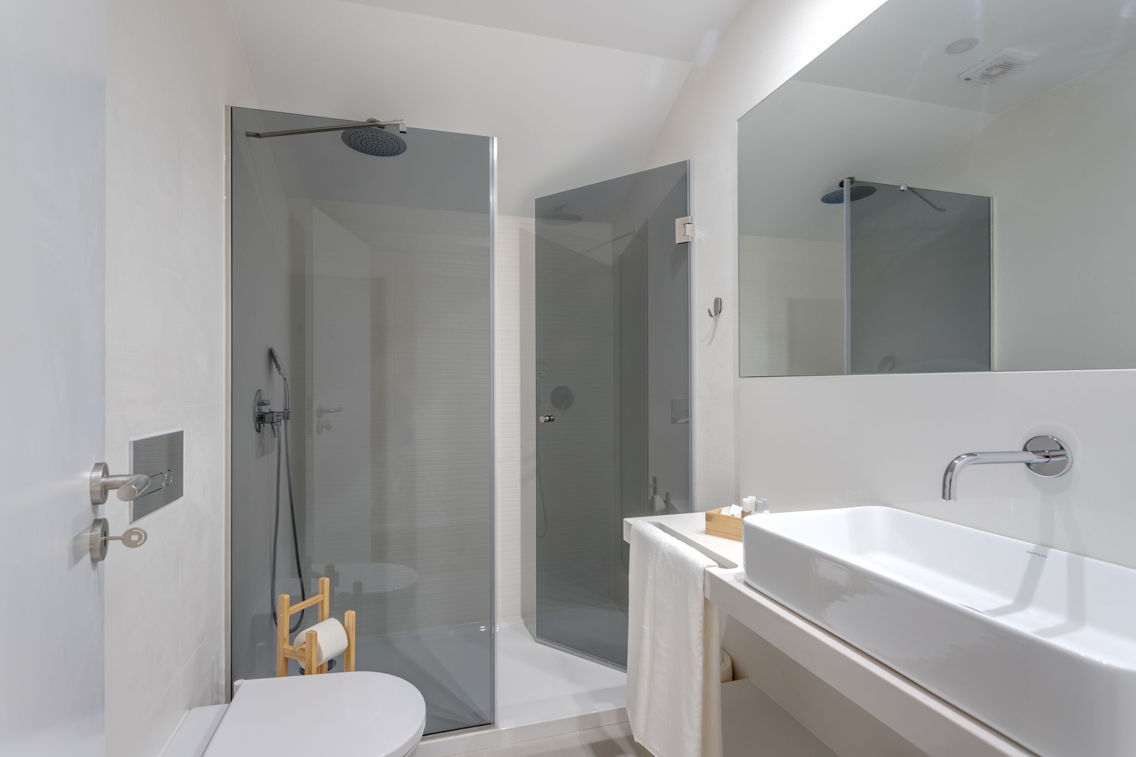 Maisonnette | Badkamer | Een douche, een haardroger, handdoeken