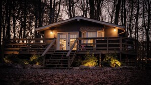 A cabin with a wooden deck, a staircase, and a porch. - Cozy Cottage in Locust Lake w/ Seasonal Lake Views (pocono Lake)