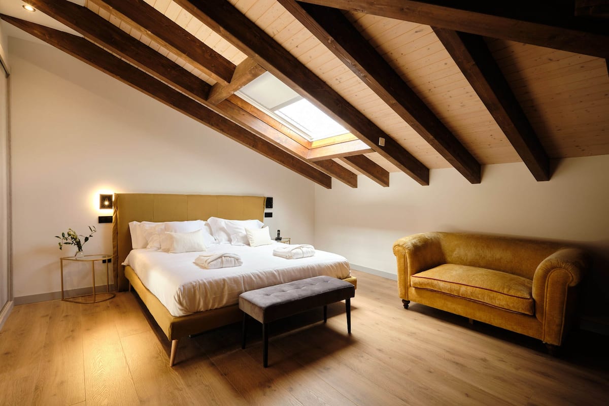 Une chambre à coucher avec un lit, un banc et un canapé.