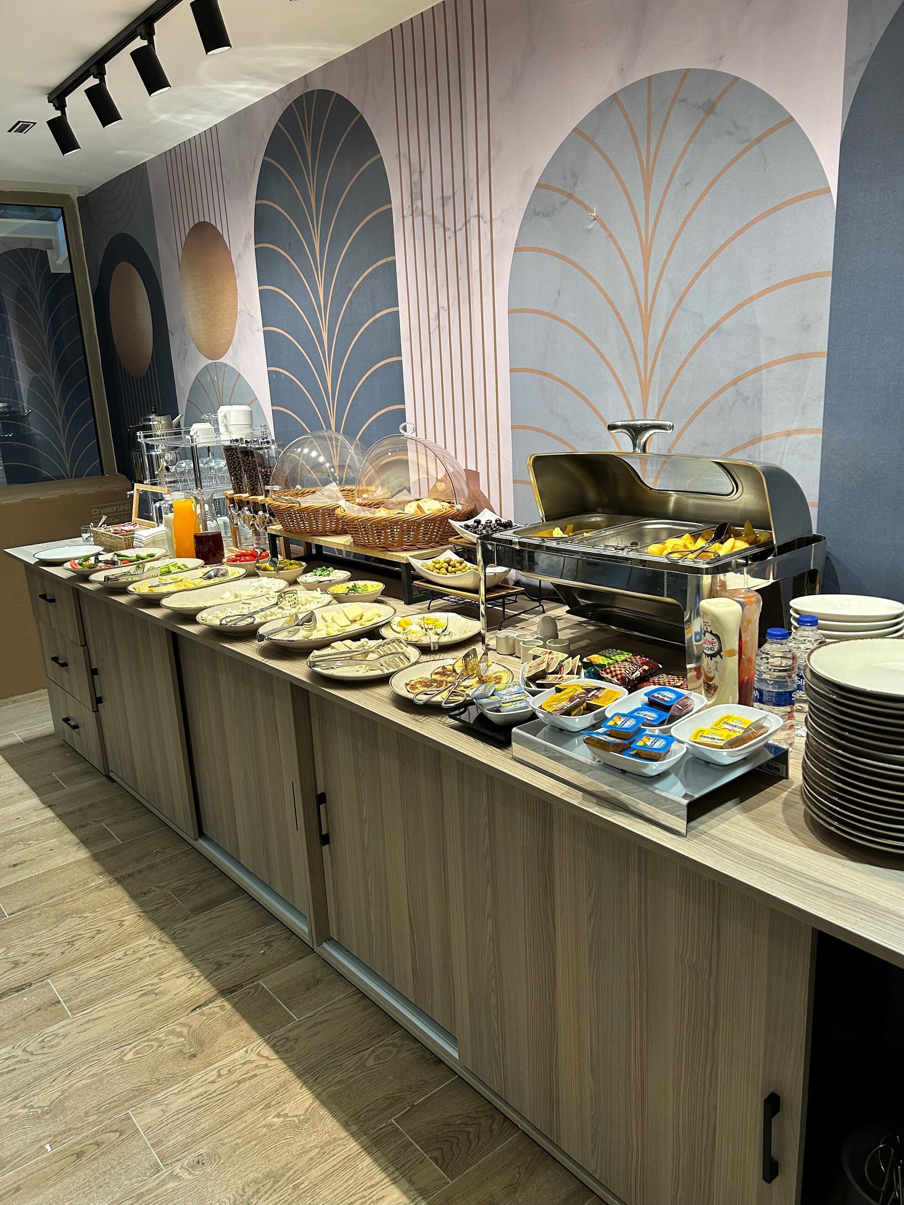 A buffet setup with various food items, a coffee machine, and a juice dispenser.