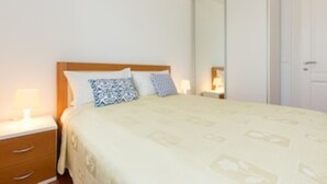 A bedroom with a bed, two bedside tables, a wardrobe, and a mirror. - 4-star apartments with direct beach access in front of the house (Crikvenica)