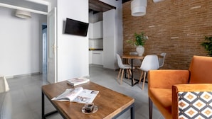Un espace de vie moderne comprenant un coin repas, une table basse avec un magazine et une tasse, et un mur en briques.