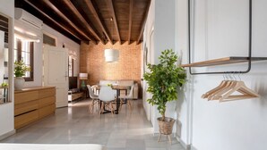 Un interior moderno con paredes de ladrillo visto, un comedor y una planta pequeña.