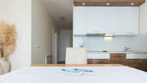 Una habitación de hotel con cama, una mesita y vistas a la cocina.