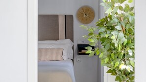 Un dormitorio con una cama, un adorno redondo en la pared y una planta en maceta.