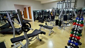 A gym with various exercise equipment including treadmills, weight machines, and free weights. - Hotel Capital da Fé (Aparecida)
