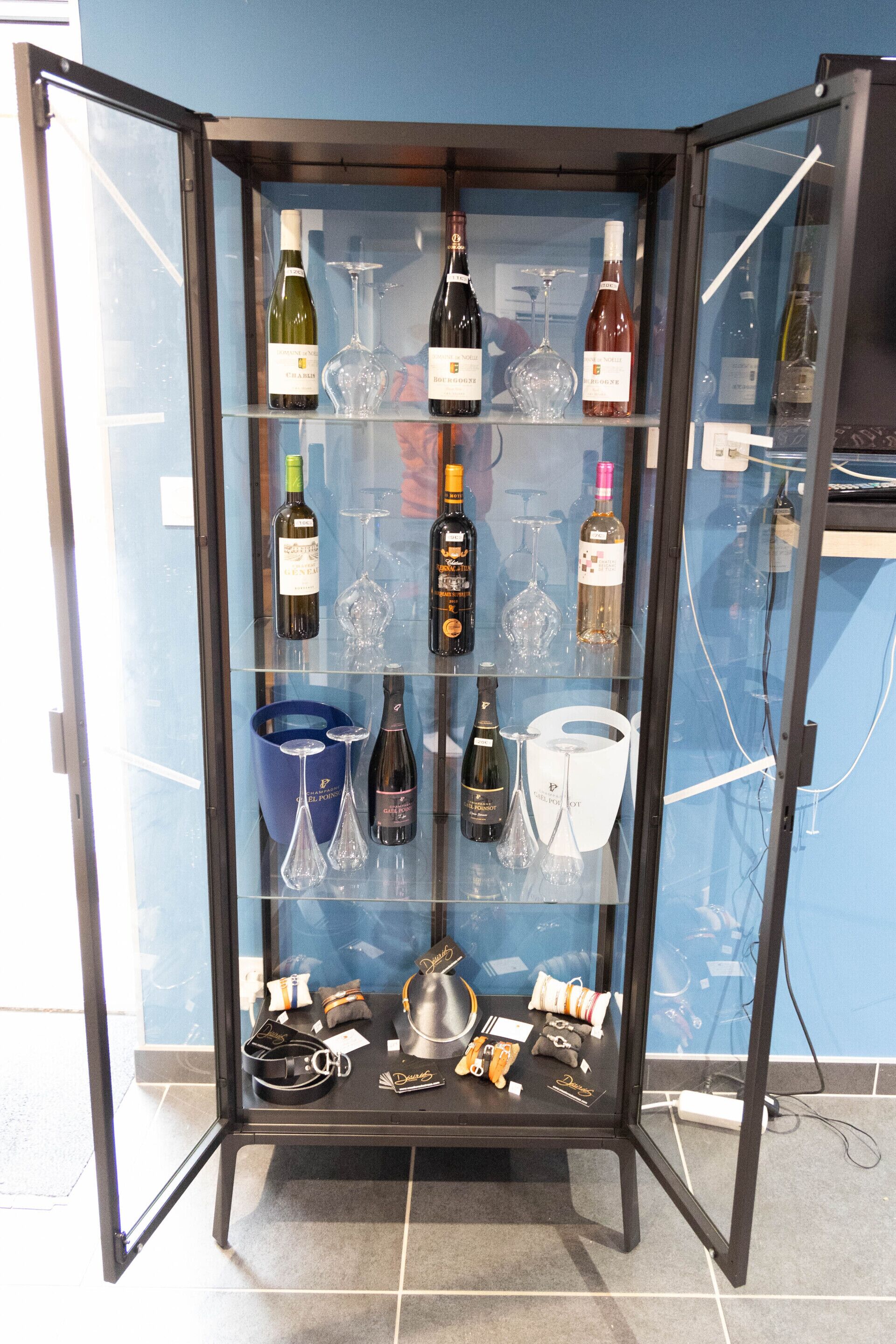 Una vitrina con botellas de vino y copas.