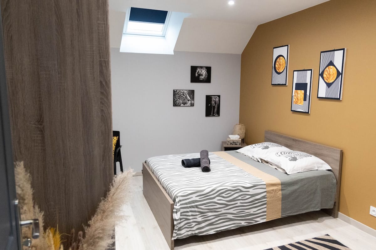 Ein Schlafzimmer mit Bett, Nachttisch, Lampe und Wandbildern.