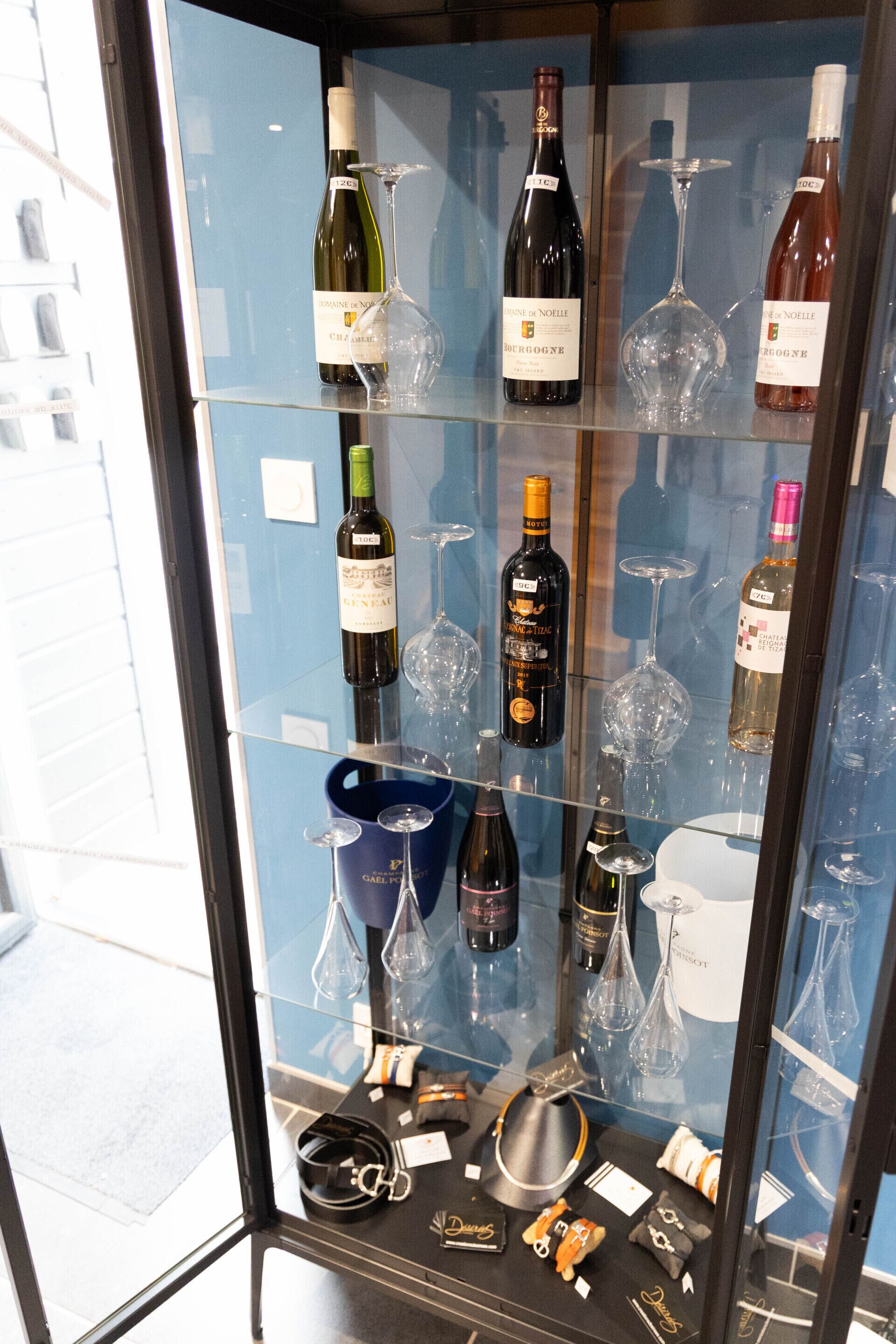 A wine display case with various bottles and glasses.