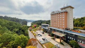 A hotel with a modern design, a parking area, and a view of a lake. - Shuang Bai Hotel (Shuangbai)