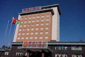 A multi-story hotel building with a prominent sign at the top. - Shuang Bai Hotel (Shuangbai)