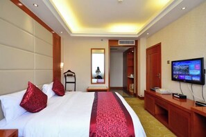 Una habitación de hotel con cama, televisión, espejo y armario.