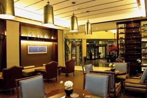 A lobby with seating arrangements, a reception desk, and a bookshelf.