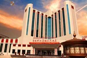 Un edificio grande con una entrada destacada y un toldo decorativo.
