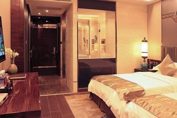 A modern hotel room with a large bed, a desk, and a mirror. - Shandong Building (Shigatse)