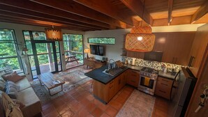 Uma cozinha ampla com uma ilha grande, armários de madeira e uma luminária pendente moderna.