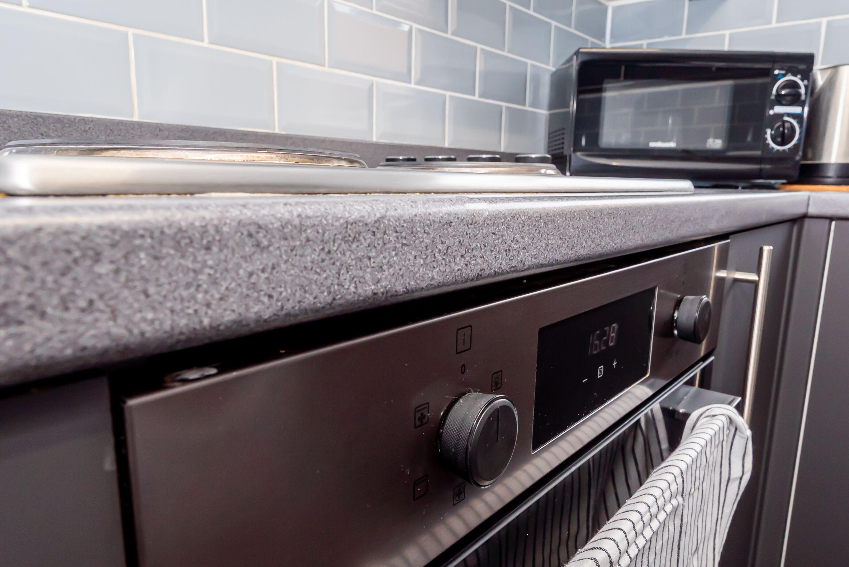 Uma cozinha com micro-ondas, fogão e painel de controle digital para o forno.