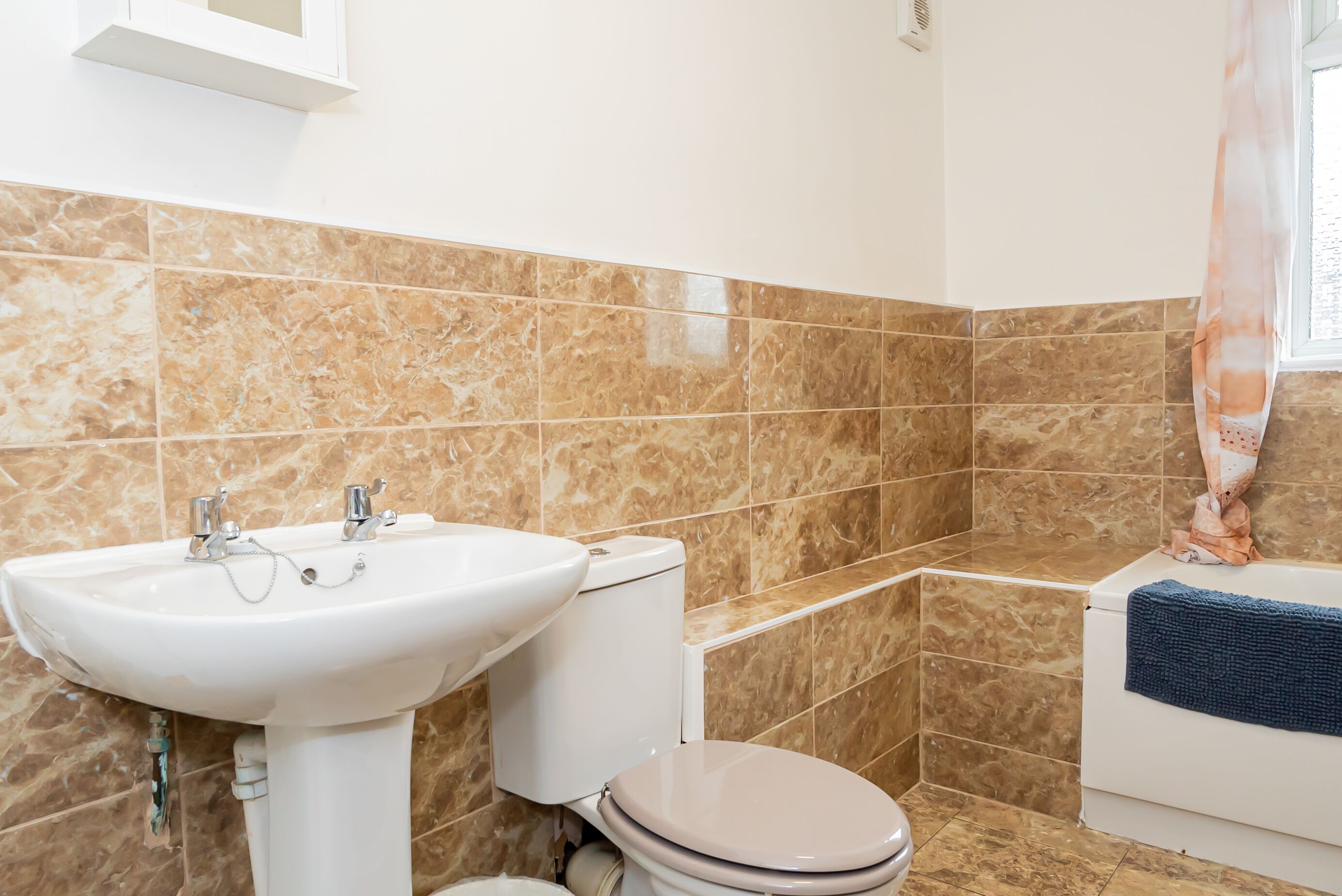 A bathroom with a sink, toilet, and bathtub.