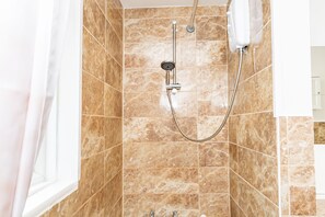 A bathroom with a shower, tiled walls, and a window. - Shirley House 3 Guest House Self Catering  (Southampton)