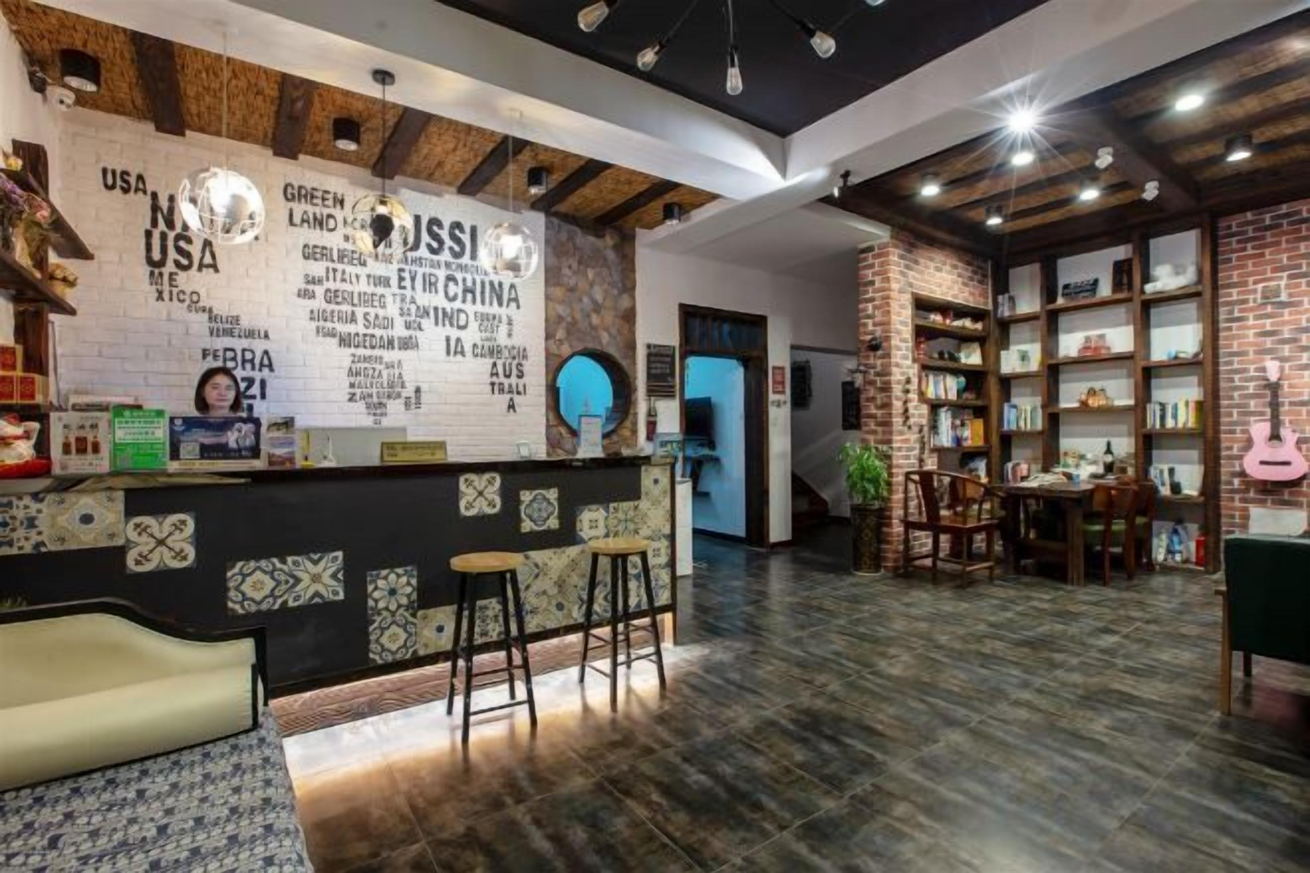 Un área de recepción con mostrador, taburetes de bar y una pared con texto y logotipos.