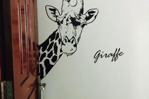 En giraffbild som sitter fast på en vägg.