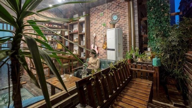 Un intérieur chaleureux avec un banc en bois, des étagères et des plantes en pot.