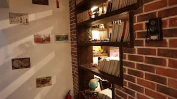 Una pared de ladrillo con estantes que contienen libros y objetos decorativos.