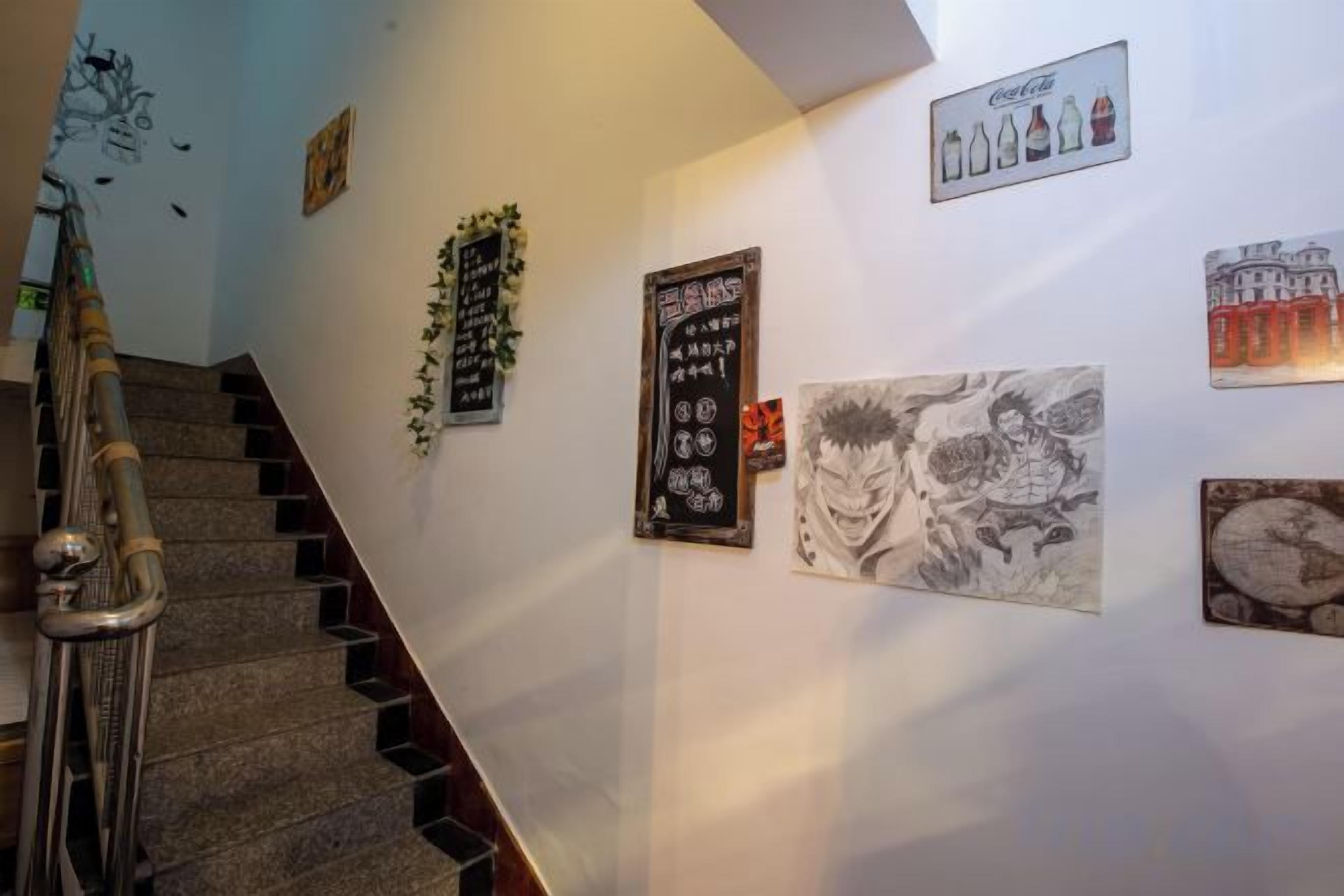 Una escalera con barandillas y una pared decorada con varios objetos enmarcados.