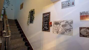 Una escalera con barandillas y una pared decorada con varios objetos enmarcados.