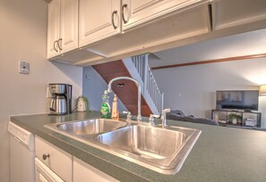 Enjoy cooking in this well-equipped kitchen with a coffee maker and stainless steel sink.